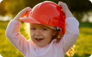 Little girl in builder's hat